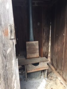 Inside wooden outhouse.