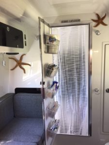 RV bathroom with a shower curtain in front of door.