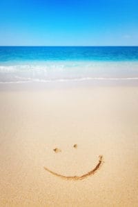Beach with happy face in sand.