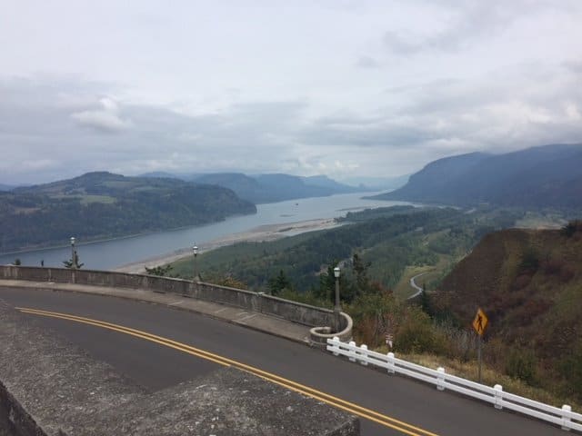 Scenic view of Columbia River with mountains and highway.