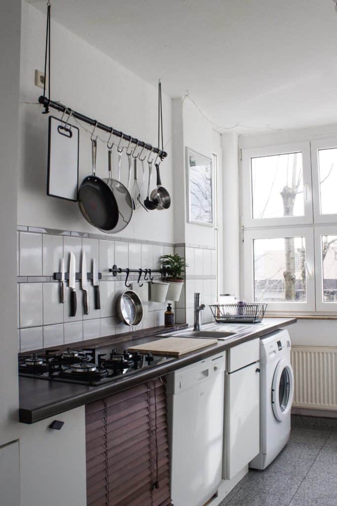 White kitchen in a tiny home, including a washer-dryer all-in-one for doing laundry. Photo by Dinh Ng. on Unsplash.