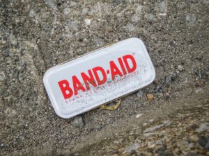 Box of band-aids in the sand. Photo by Franck V. on Unsplash