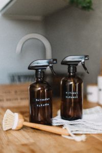 Two brown spray bottles and the scrub brush Photo by Daiga Ellaby on Unsplash