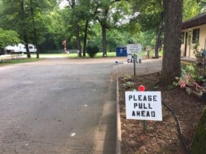 Road in an RV park with a sign that reads, "Please pull forward."