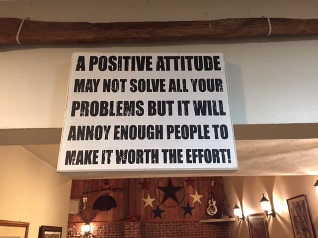 A sign that reads, "A positive attitude may not solve all your problems but it will annoy enough people to make it worth the effort."