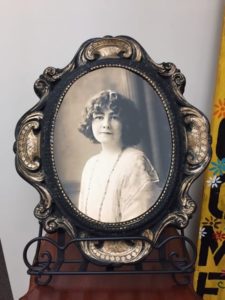 Old fashioned black and white photo of a young woman. It's in an old fashioned oval frame.