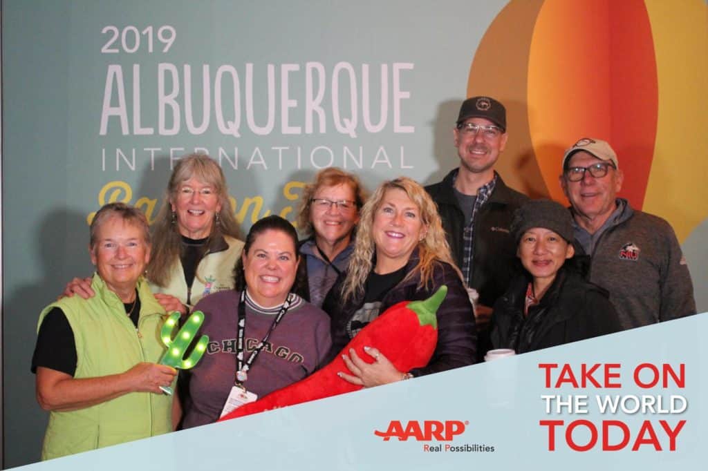 Group photo in front s a sign that reads 2019 Albuquerque Balloon Fiesta. 