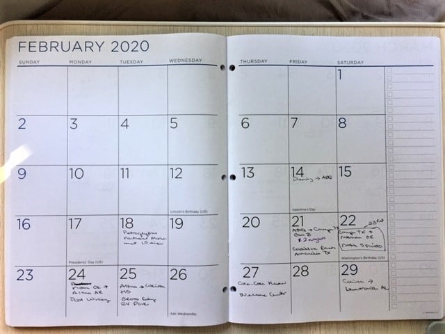 Monthly planner opened up to February 2020 with various things written on dates which serves as a travelogue overview.