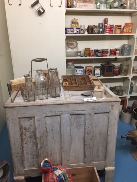 An old fashioned grocery with a display for milk, eggs, flour on an wooden box.