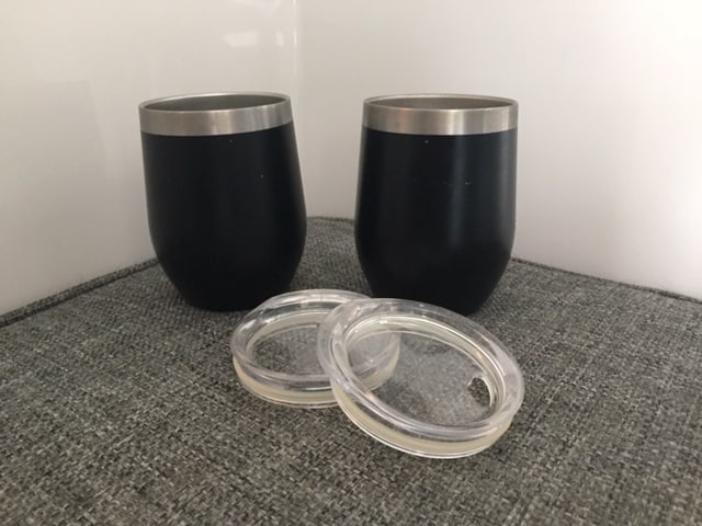 Two black cups with two lids sitting in front of them. Great RV kitchen gadgets that don't break.