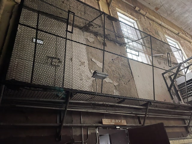 A large cage attached to the side of a wall.
