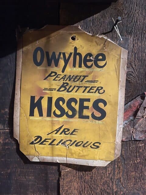 Old candy paper sign that says, "Owyhee Peanut Butter Kisses are Delicious."