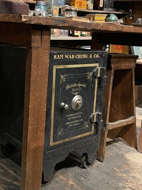 Old black floor dial safe with Kam Wah Chung and Co. written on top.