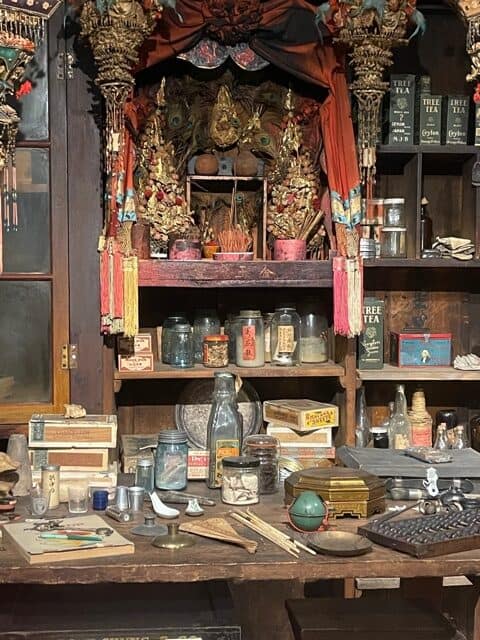 Chinese altar inside a 1940 general store with lots of products in jars.