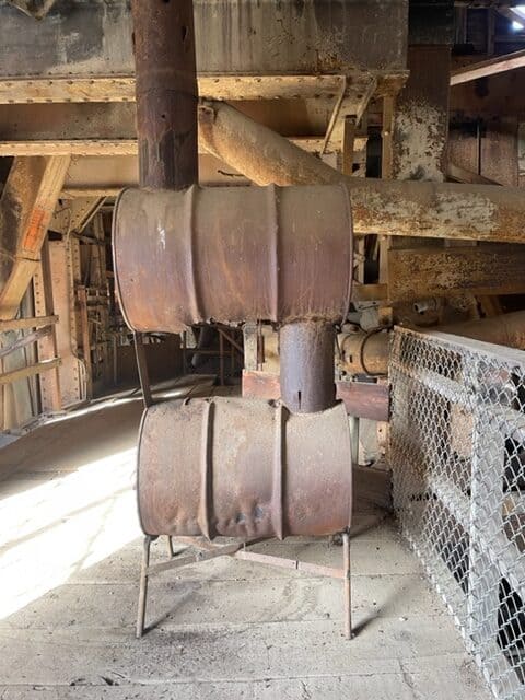 Old rusted barrels stacked on one another to serve as a stove.