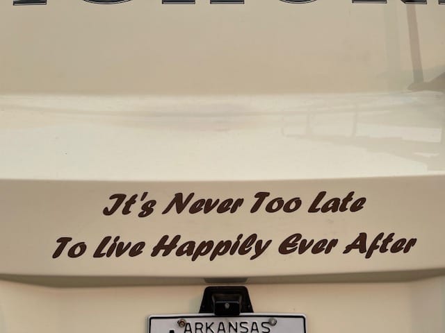 The back of an RV with the words, "It's Never Too Late to Live Happily Ever After."