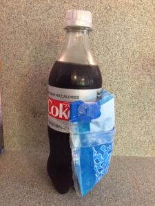 Diet Coke bottle with a blue gel ice pack wrapped around it.