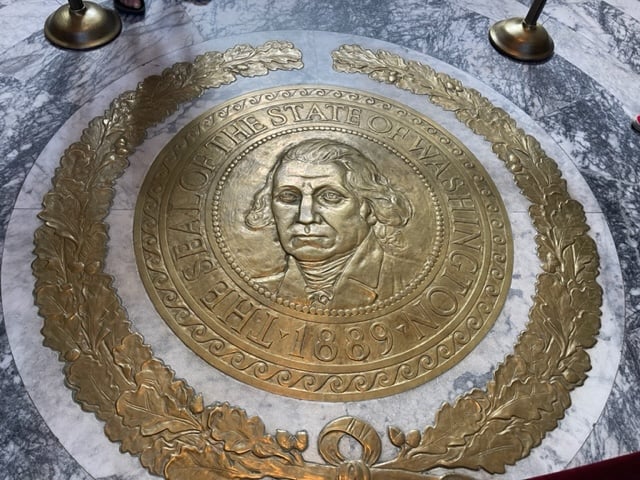Close up of the state seal of Washington with George Washing in the middle.