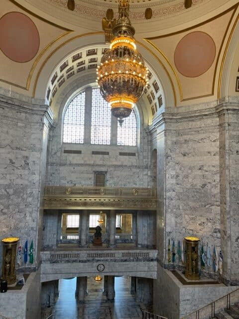 A hanging lit huge glass and metal chandelier.